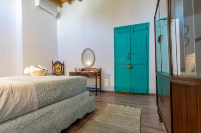 a bedroom with a green door and a bed and a mirror at Casa Ifestou in Rhodes Town