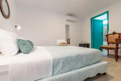 a bedroom with a white bed and a blue door at Casa Ifestou in Rhodes Town