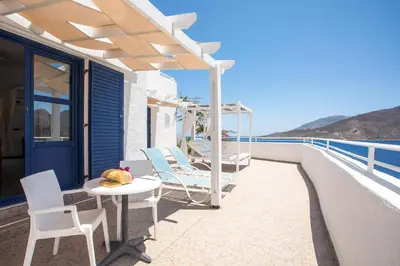 a patio with chairs and a table and a view of the ocean at ILIDI Rock in Livadia