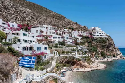 a group of white houses on a hill next to the ocean at ILIDI Rock in Livadia