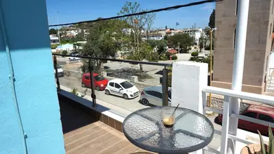 a balcony with a table and a view of a street at Summer scoop studio by EvaGstays in Faliraki
