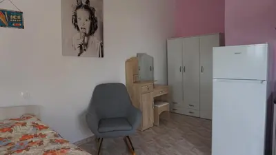 a bedroom with a chair and a desk and a refrigerator at Summer scoop studio by EvaGstays in Faliraki
