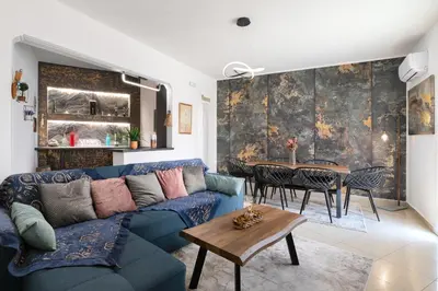 a living room with a blue couch and a table at Le Peridot Garden House in Rhodes Town