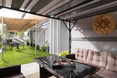 a patio with a couch and a table at Le Peridot Garden House in Rhodes Town