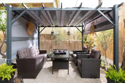 a pergola patio with furniture and a table at Le Peridot Garden House in Rhodes Town