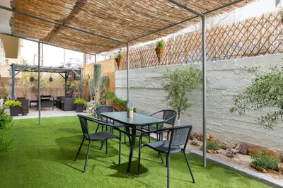 a patio with a table and chairs on grass at Le Peridot Garden House in Rhodes Town