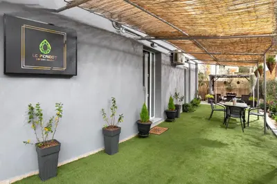 a patio with green grass and a table and chairs at Le Peridot Garden House in Rhodes Town