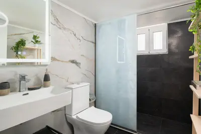a bathroom with a white toilet and a sink at Le Peridot Garden House in Rhodes Town