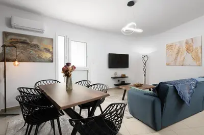 a living room with a table and chairs and a couch at Le Peridot Garden House in Rhodes Town