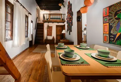 a dining room with a wooden table with green dishes on it at Casa Aletta - Old Town Apt. in Rhodes Town