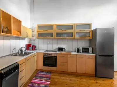 a kitchen with wooden cabinets and a stainless steel refrigerator at Casa Aletta - Old Town Apt. in Rhodes Town