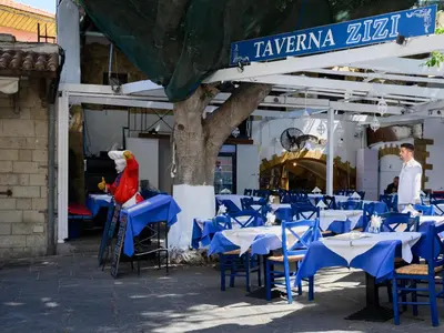 a group of tables and chairs in front of a restaurant at Casa Aletta - Old Town Apt. in Rhodes Town