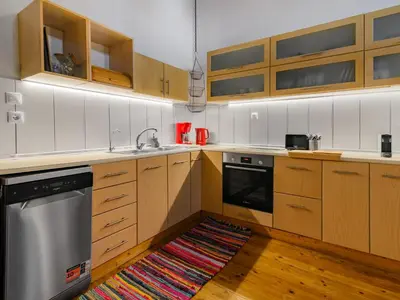 a kitchen with wooden cabinets and a rug on the floor at Casa Aletta - Old Town Apt. in Rhodes Town