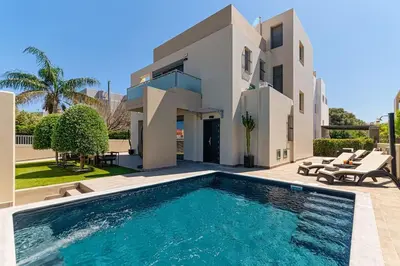 a villa with a swimming pool in front of a house at Villa Serenity in Ialyssos