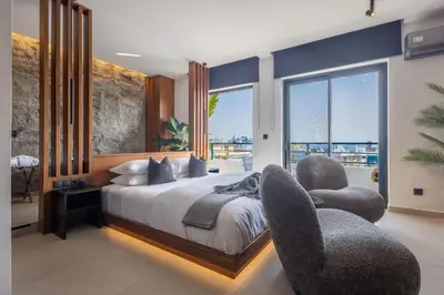 a bedroom with two chairs and a bed with a view at The Suite in Rhodes Town