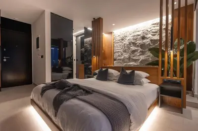 a bedroom with a large bed with a painting on the wall at The Suite in Rhodes Town
