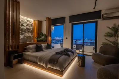 a bedroom with a large bed in a room with windows at The Suite in Rhodes Town