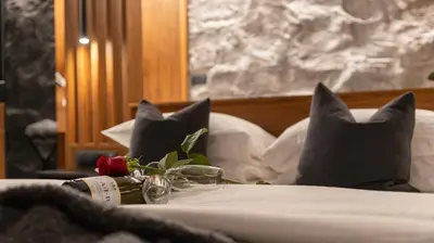 a bed with black pillows and a rose on it at The Suite in Rhodes Town