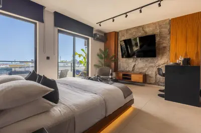 a bedroom with a large bed and a large window at The Suite in Rhodes Town