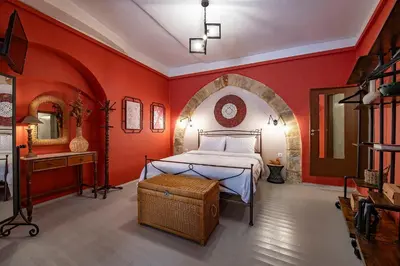 a bedroom with a bed in a red wall at Old Town Corner Luxury Studios in Rhodes Town