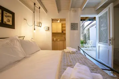 a bedroom with a large white bed and a door at Old Town Corner Luxury Studios in Rhodes Town