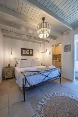 a bedroom with a large bed with a chandelier at Old Town Corner Luxury Studios in Rhodes Town