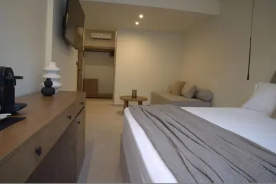 a large bedroom with a bed and a couch at Rhotheon Suites in Ialysos Rhodes - private pool in selected rooms in Ialyssos