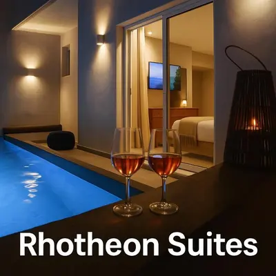 two glasses of wine sitting on a table in a hotel room at Rhotheon Suites in Ialysos Rhodes - private pool in selected rooms in Ialyssos