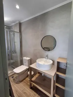 a bathroom with a sink and a toilet and a mirror at Almira Beach House in Kiotari