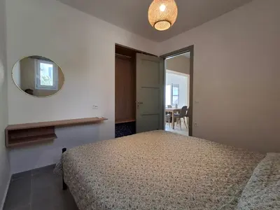 a bedroom with a bed and a mirror at Almira Beach House in Kiotari
