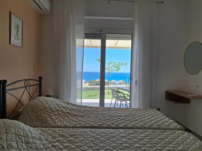 a bedroom with a bed and a view of the ocean at Almira Beach House in Kiotari