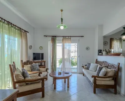 a living room with a couch and chairs and a table at STEGNA REA Seaside Apartment in Archangelos