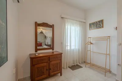 a bathroom with a mirror and a wooden dresser at STEGNA REA Seaside Apartment in Archangelos