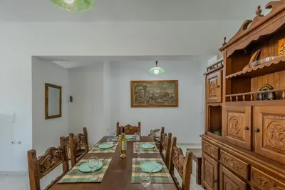 a dining room with a long table and chairs at STEGNA REA Seaside Apartment in Archangelos