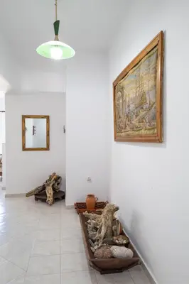 a white room with a painting on the wall and a table at STEGNA REA Seaside Apartment in Archangelos