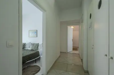 a bedroom with a bed and a hallway with a mirror at STEGNA REA Seaside Apartment in Archangelos