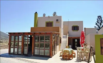 a building with a table and chairs in front of it at Asimenis Cottages in Kattavía
