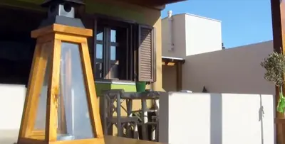 a wooden lantern sitting on the balcony of a house at Asimenis Cottages in Kattavía