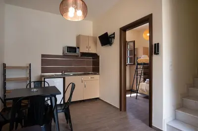 a kitchen and dining room with a table and a kitchen and a room at Asimenis Cottages in Kattavía