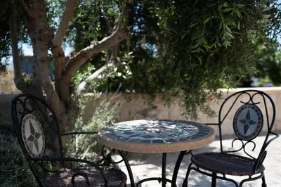 a table and two chairs sitting next to a tree at Asimenis Cottages in Kattavía