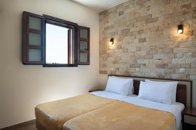 a bedroom with a large bed and a window at Asimenis Cottages in Kattavía