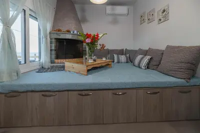 a living room with a couch and a fireplace at Aegean Sunrise View in Archangelos
