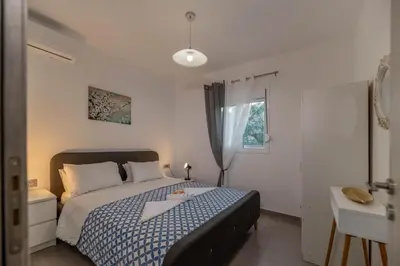 a bedroom with a bed and a desk and a window at Aegean Sunrise View in Archangelos