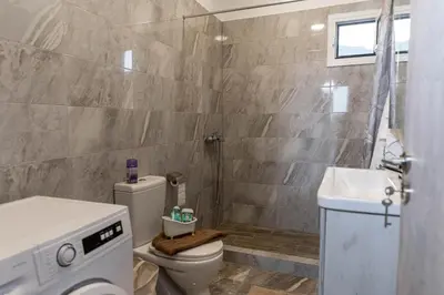 a bathroom with a toilet and a sink at Aegean Sunrise View in Archangelos