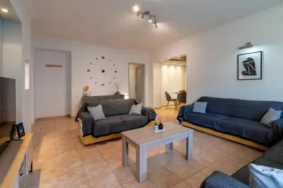 a living room with two couches and a table at Berry apartment in Ixia