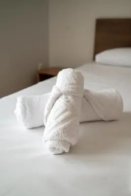 a stack of white towels on a bed at Berry apartment in Ixia