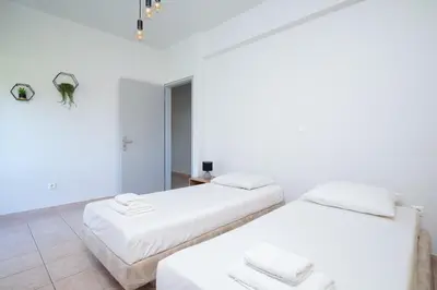 two beds in a room with white walls at Berry apartment in Ixia