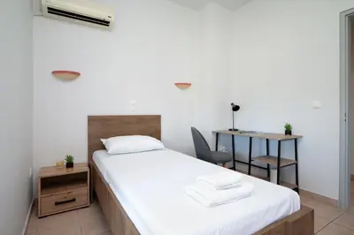 a bedroom with a bed and a desk with a chair at Berry apartment in Ixia
