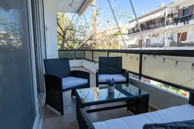 a balcony with two chairs and a table and a boat at Berry apartment in Ixia