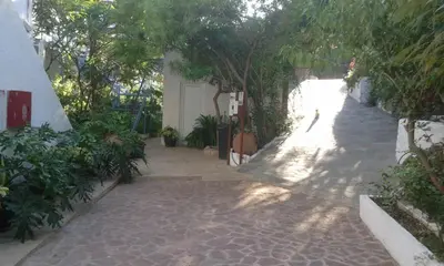 a brick walk way with trees and a building at Milios Studios in Megálon Choríon